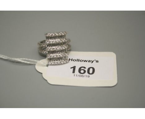 A multi tiered diamond ring, channel set with baguette diamonds between rows of brilliant cut diamonds with diamond set two r