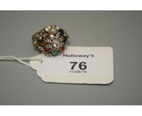 A multi-gem set bombe form cluster ring, with the cabochon stones including ruby, sapphire and tigers eye within a filigree m