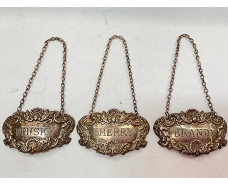 Three silver spirit labels