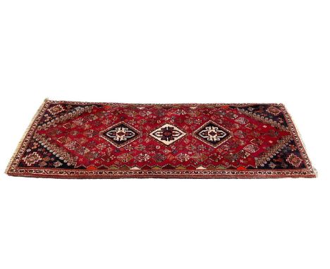 Eastern runner with three central medallions on red and blue ground, 198cm x 74cm