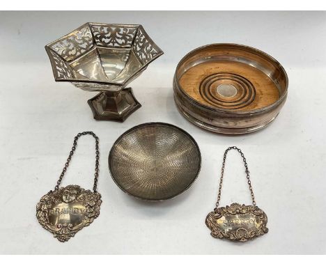Silver wine coaster, pieced silver pedestal dish, silver pin dish and two silver spirit labels