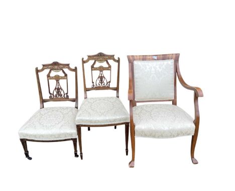 Two Victorian inlaid rosewood chairs with cream upholstered seats together with another elbow chair with matching upholstery 