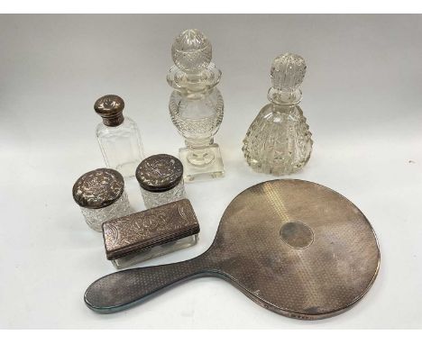 Silver backed dressing table mirror, four silver topped glass vanity jars and two cut glass perfume bottles