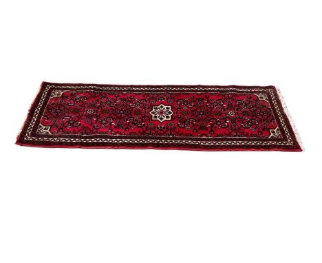 Eastern runner with central medallion on red and cream ground, 192cm x 69cm