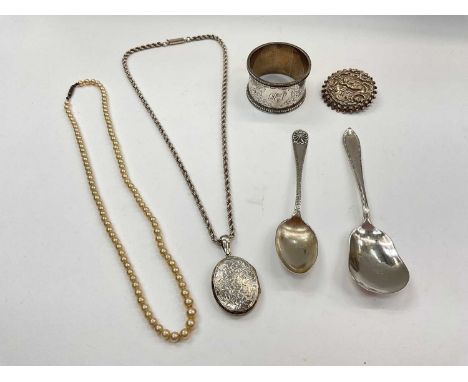 Silver napkin ring, two silver spoons, silver brooch, white metal locket on rope twist chain and a simulated pearl necklace 