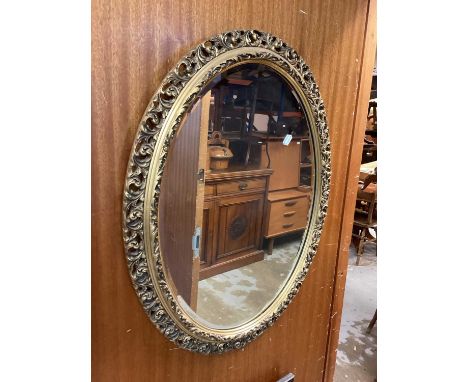 Oval bevelled wall mirror in ornate gilt frame with pierced decoration, 72cm x 56cm