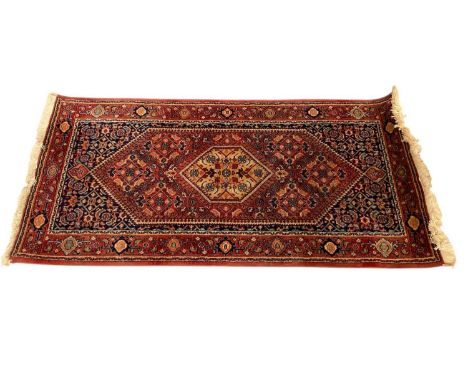 Afghan runner with central medallion on red and blue ground, 140 x 71.5cm