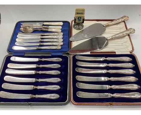 Two cased sets of six silver handled butter knives, two silver handled cake slices, plated cutlery and a silver calendar hold