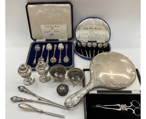 Box of assorted silver to include an embossed silver hand mirror, cased set of six coffee spoons, cased set of six teaspoons,