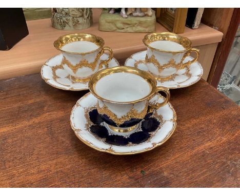 Three Meissen gilt moulded breakfast cups and saucers, the saucers 15.75cm diameterSmall chip to one foot rim, tiny flee bite