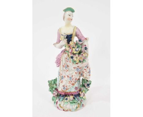 Bow figure of a young woman, circa 1765, shown standing holding flowers, on a scrollwork base, polychrome painted, workman's 