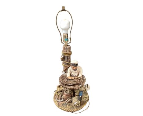 Ceramic lamp of a sailor building a model boat, measuring approximately 63cm tall