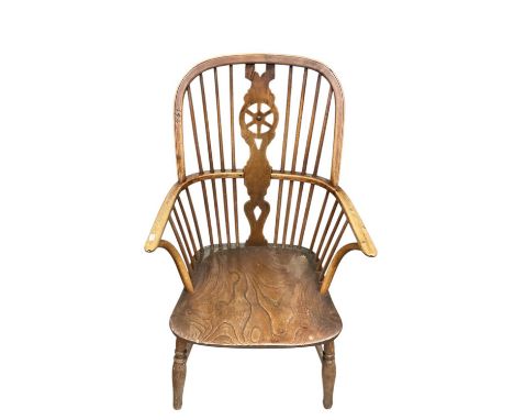 Early 19th century yew, ash and elm wheel back Windsor chair, having saddle seat on turned supports with H-shaped stretcher.
