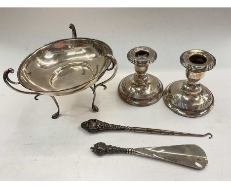Silver dish raised on three feet, pair of silver squat candlesticks and two silver handled items 