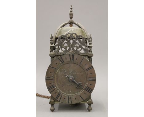 A brass lantern clock, the dial inscribed 'Thos Moore Ipswich' together with a wooden wall bracket. The clock 35 cm high.