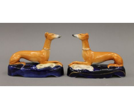A pair of Staffordshire mid-19th century pottery coursing greyhounds: a handsome left and right pair of fawn greyhounds weari