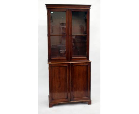 A VICTORIAN MAHOGANY BOOKCASE in two parts with glazed upper half and panelled doors below on bracket feet, 90cm wide x 207cm
