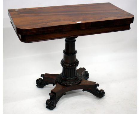 AN EARLY VICTORIAN ROSEWOOD FOLD OVER CARD TABLE with a turned and reeded column support and four scrolling feet, 91cm wide 