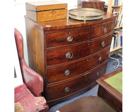 AN EARLY 19TH CENTURY MAHOGANY BOW FRONTED CHEST OF TWO SHORT AND THREE LONG DRAWERS with brass ring handles, standing on bra