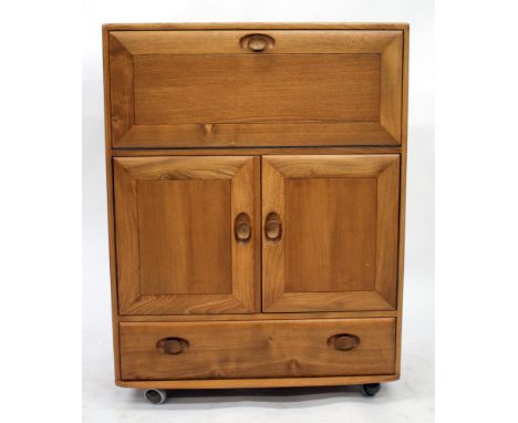 AN ERCOL LIGHT ELM SIDE CABINET with a fall front above two panelled doors and a drawer, 81cm wide 