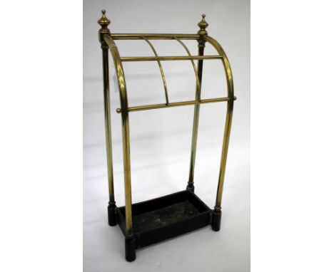 A VICTORIAN BRASS AND CAST IRON STICK STAND with two finials, a curved front and six compartments, 30cm wide