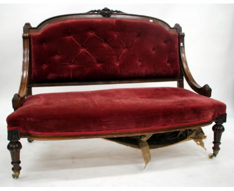 A VICTORIAN MAHOGANY FRAMED SETTEE with button upholstered back and upholstered seat, carved and fluted legs terminating in c