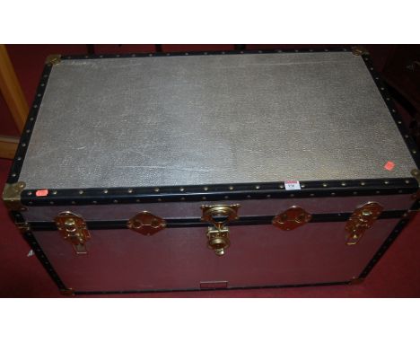 A metal bound hinge-top travelling trunk with end carry handles 
