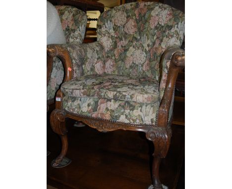 A pair of late 19th century carved oak and floral button back upholstered armchairs, each having masked gryphon terminals and