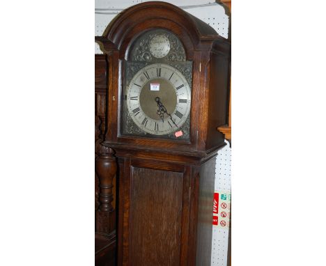 An early 20th century Tempus Fugit oak longcase clock having an arched brass and silver dial, three train movement with pendu