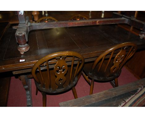 An Ercol dark elm drawer leaf dining table, together with a set of four Ercol dark elm splat back dining chairs (5)