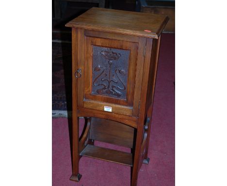 An Art Nouveau walnut pot cupboard having integral lower book trough