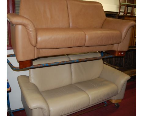 A Stressless light tan leather three seater sofa, together with a matching cream leather example (2)