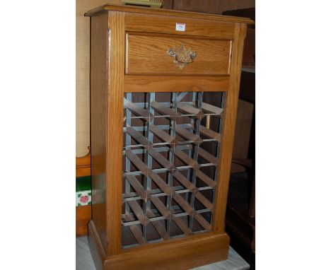 A light oak freestanding 24 division wine rack, having single long upper drawer