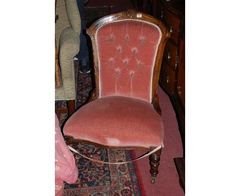 A Victorian walnut framed and line carved pink upholstered button back nursing chair