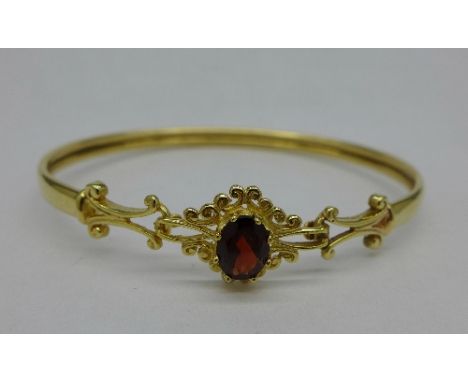 A 9ct gold and garnet bangle, 6.3g