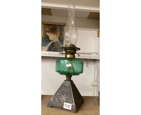 A Victorian oil lamp with green glass shade
