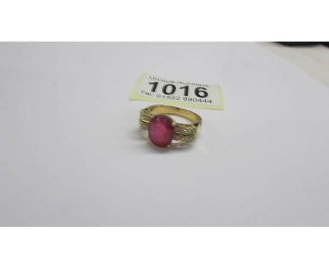 An 18ct white/yellow gold oval ruby and diamond ring, size O half, 6.2 grams.