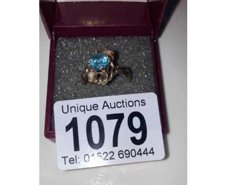 A vintage blue zircon ring set with two pearls in a rope twist setting stamped 10ct gold size L 1/4