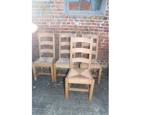 A set of four oak ladder back chairs with rush envelope seats, on square stretched supports 