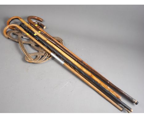 An ebony and bone inlaid stick, four walking sticks, a shooting stick and a carpet beater 