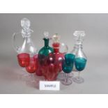 A Georgian cut glass three-ring neck decanter, two other glass decanters, a glass carafe, a green