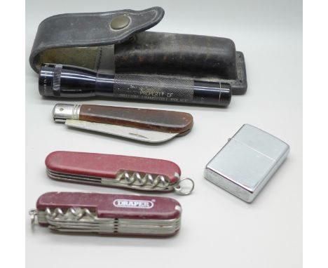 A Zippo lighter, a Swiss Army knife, two other knives and a British Transport Police Mini-Maglite torch in a leather case 