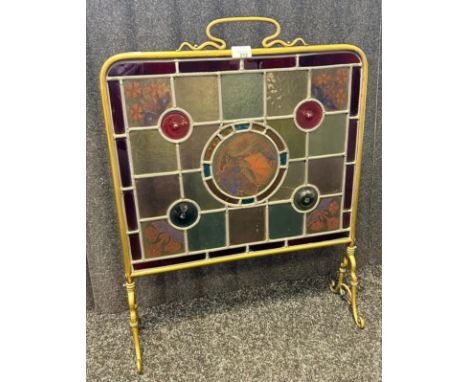 An antique brass framed fire screen with central hand painted stained glass centre. [71.5x53.5x19.5cm]