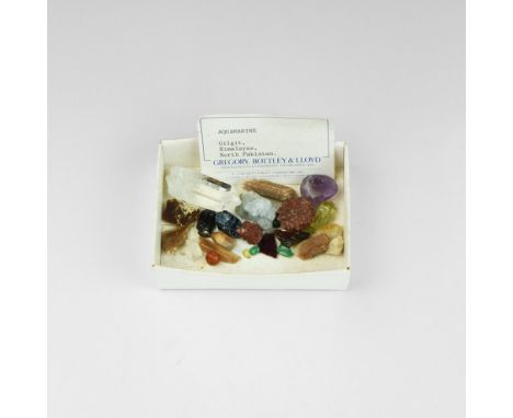 A mixed group of mineral specimens in a white card collector's tray, including amethyst, rock crystal, carnelian, agate and o
