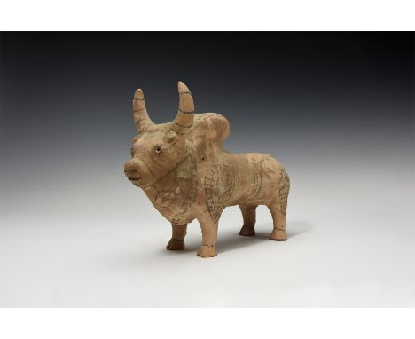 An undated archaistic hollow-formed ceramic zebu figurine with painted detailing to the body and horns, vent to the neck.  99