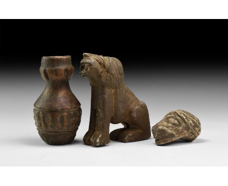 An undated archaistic group of carved stone items comprising: a lion sitting on its haunches with mouth open; a bulb finial w