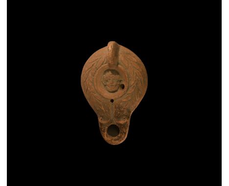 19th century AD. An antique or earlier Roman ceramic oil lamp in 2nd century AD style with round nozzle, scroll to each side,