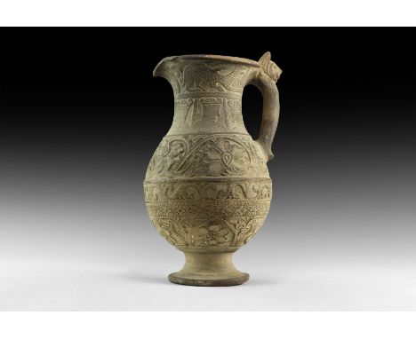 An undated archaistic ceramic ewer with flared base, bands of tendril and vegetation ornament to the body, profile busts to t