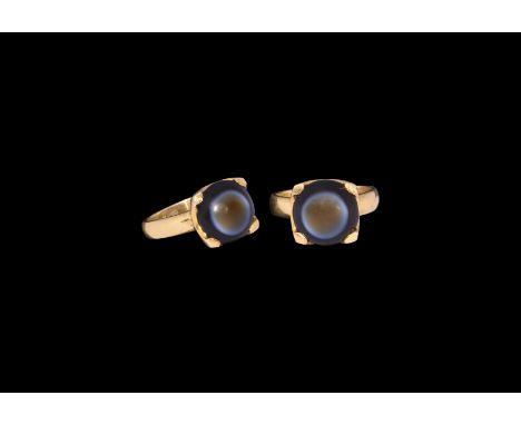 20th century AD. A gilt ring comprising a flat-section hoop, square bezel with claw to each angle, inset banded agate cabocho
