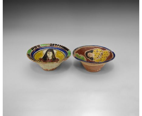 A group of two glazed ceramic bowls, one with two squatting robed figures and a central roundel, the other with a nimbate rob